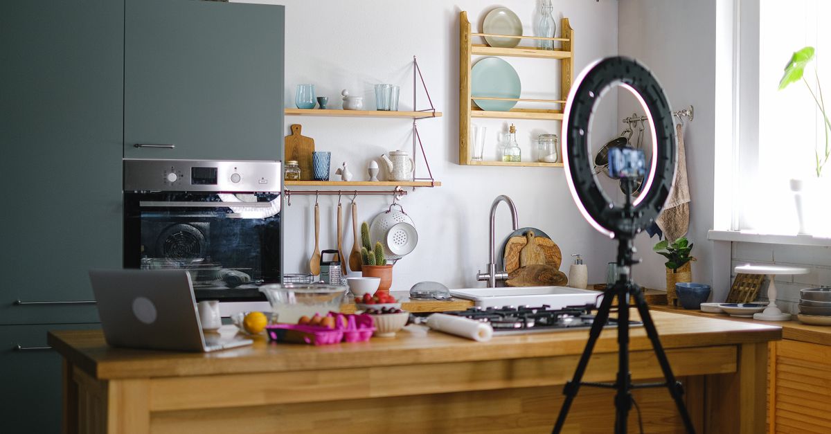 Contemporary kitchen interior with baking setup, laptop, and ring light, perfect for content creation.